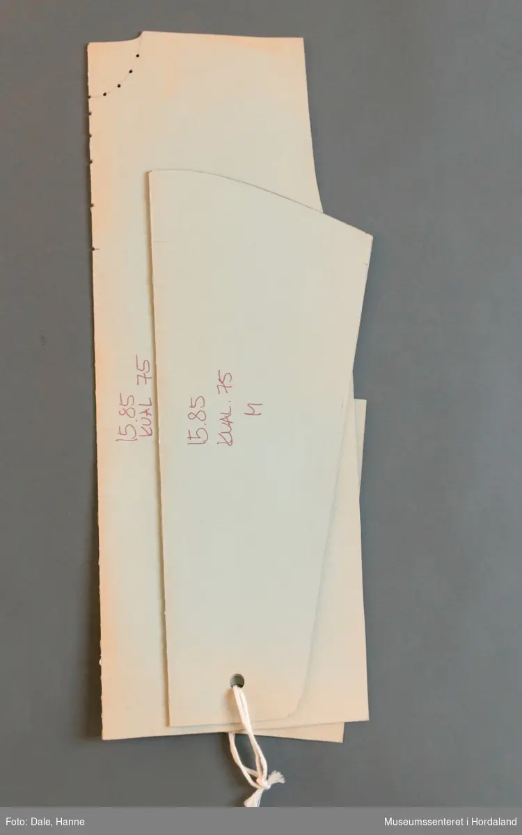 Mønsterskante i papp, brukt til å skjere ut ulike delar av plagg i klesproduksjon. Desse er til ein genser i str. M, art. nr. 15.85.