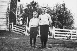 Gutter, klær, gjerde, bygning.