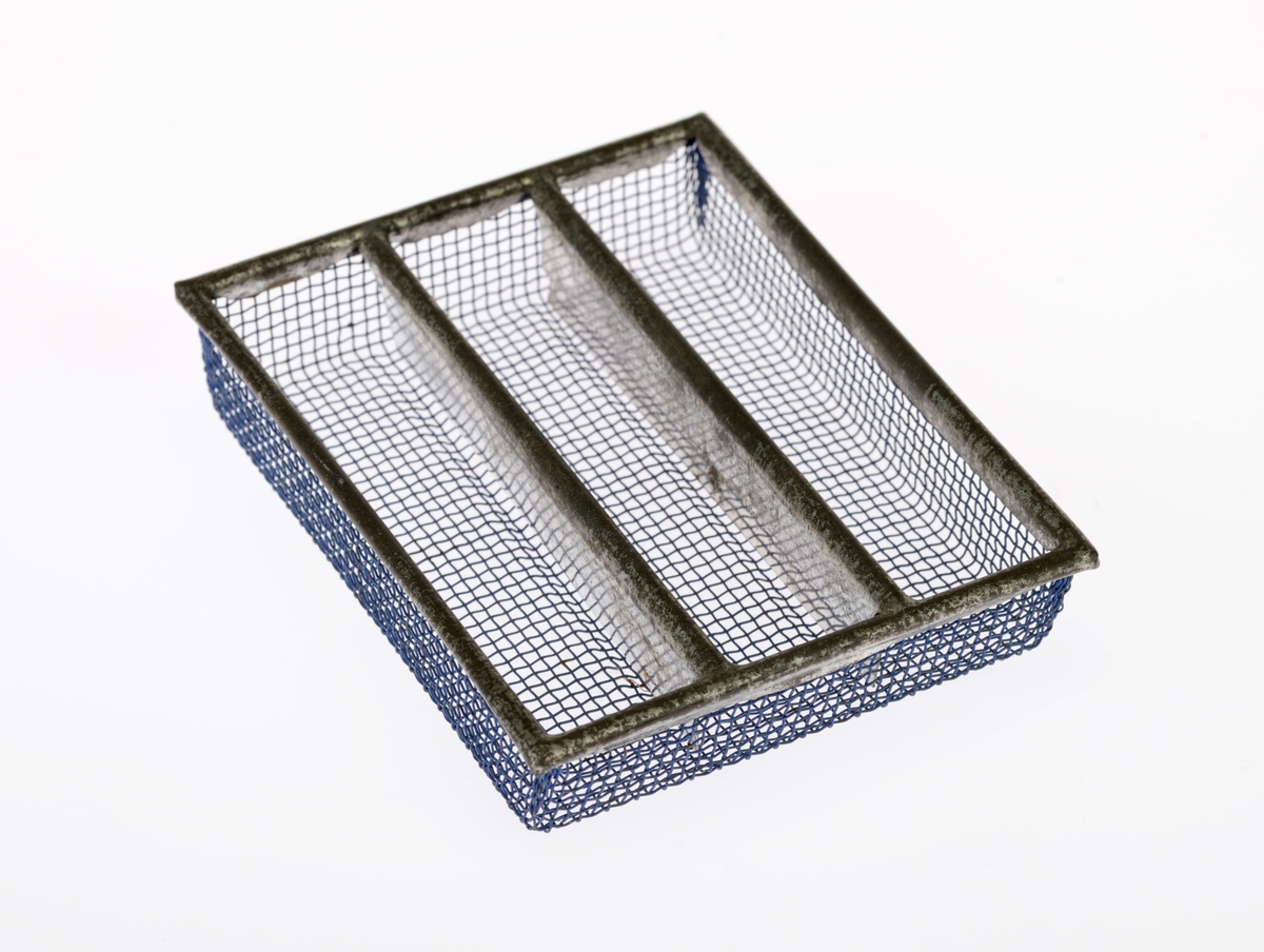 En liten bestikkurv med lekebestikk i. Alt er laget av metall. Gjenstandene er undernummerert 01-08, på de minste gjenstandene står kun undernummeret da det ikke var plass til hele FTT-nummeret.
FTT.54449.01: En trådkurv laget av blå metallnetting som er falset sammen med blankt metall. Bestikkurven har tre rom.
FTT.54449.02-03: To kniver med bredt blad og avrundet i enden. Skaftet har prikkmønster langs kanten og en opphøyet stripe i midten.
FTT.54449.04-05: To gafler med lik utforming men av ulik størrelse. Begge har fire tenner. På skaftet er det prikkmønster langs kanten og en opphøyet stripe på midten.
FTT.54449.006-07: To identiske skjeer. På skaftet er det prikkmønster langs kanten og en opphøyet stripe på midten.
FTT.54449.08: En liten øse med rundt hode. Skaftet er rundt før det blir flatt i enden. I endene er det også krokformet (for oppheng).