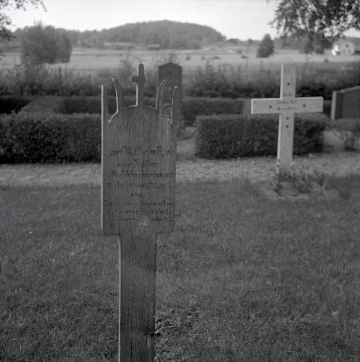 Gravvårdar av trä på en kyrkogård i Vena socken.