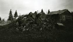 Steinrøys i Galåsen. Tømmerhus (smie) i bakgrunnen til høyre