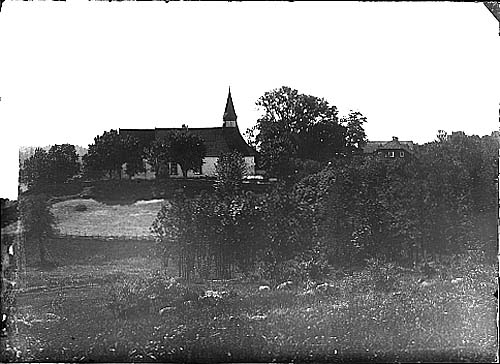 Ölmstad kyrka från norr. I svackan vid gärdsgården på bilden går idag "anslutningsvägen" mellan gamla Riksettan och motell Vätterleden. Till höger skymtar den gamla prästgården som brann ner på 1940-talets början.
Glasplåt.