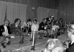 Fra festbordet under et bryllup, med brudeparet midt på bild