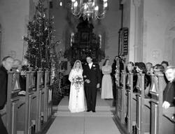 Foto fra en vielse med brudeparet i midtgangen. Bildet er tr