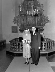 Brudefoto fra kirken, med brudeparet foran alteret. Det er u