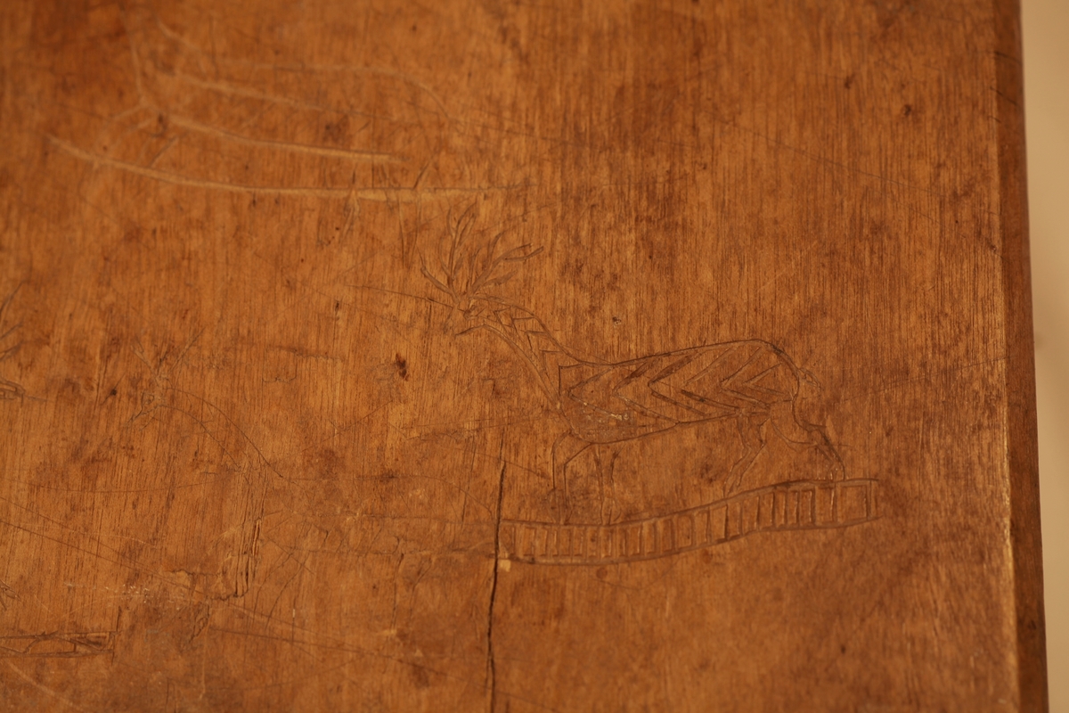 Form i tre. Utskjært motiv viser urne, blader og blomster.  Formens bakside er dekorert med hjortedyr og sidene med sirkler.