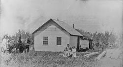 Bolighus, personer, hester, vogn.