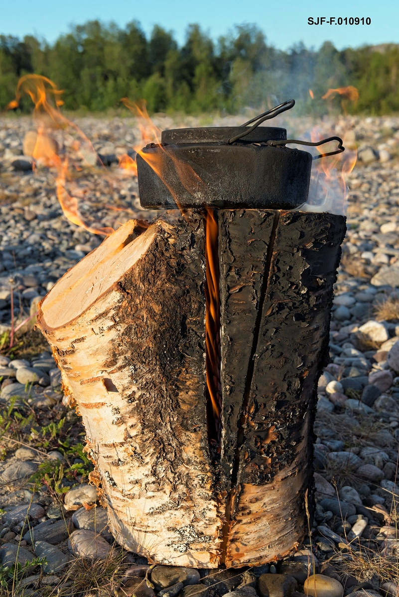 Kaffe kokes på en finneprimus ved Altaelva. Stubbfyring. Svartkjele. kaffekoking. Friluftsliv. Leirliv. Kokekaffe. Kaffe. Øvre Alta, Finnmark.
