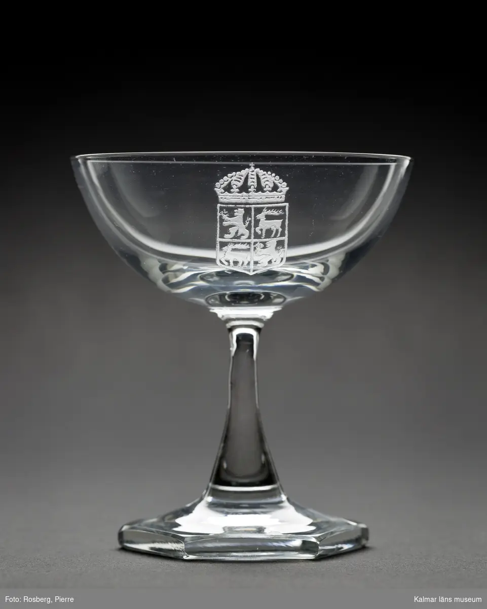 KLM 44717:18 Likörglas, av glas. Glaset är tillverkat av Orrefors glasbruk och kupan är graverad med länsvapnet.