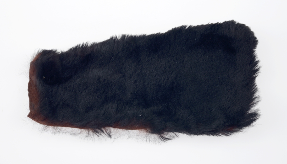 En sjokoladeeske brukt som dukkeseng med dukke, dyne, pute, skinnfell, ullteppe og madrass. Gjenstandene er undernummerert 01-08.
FTT.54432.01: En sjokoladeeske fra Freia brukt som dukkeseng. Esken er med lokk og laget av papp. Den er stiftet i hjørnene. Utenpå er det trykt julenissehoder i rødt og grønt. For tekst se "Påført tekst/merker".
FTT.54432.02: En dukke laget av plast der både armer og bein er bevegelige ved at de er festet med strikk inni dukken. Håret er støpt og er krøllet ved ørene. I ansiktet er det malt øyebryn, øyne, røde kinn og munn. Dukken har på seg en pyjamas laget av flanell. Den er stripete i fargene hvit, blå, lys oransje og grønn. På skjorten er det to knapper i fronten.
FTT.54432.03: En hodepute laget av blått bomullsstoff med heklet trekk. Puten er fyllt med diverse tekstilbiter.
FTT.54432.04: En dyne laget av blått bomullsstoff med en påsydd blondekant foran. Baksiden er sydd sammen av tre ulike tekstiler. Dynen er fyllt med tekstilbiter.
FTT.54432.05: En brunsvart skinnfell, trolig laget av kaninpels.
FTT.54432.06: Et ullteppe som trolig klippet ut av et eksisterende ullteppe. Teppet er gulhvitt med blomster og blader i rosalilla.
FTT.54432.07: Et sammenbrettet stykke som er heklet. Trolig en rest som er brukt som madrass i esken/sengen.
FTT.54432.08: Et sammenbrettet stykke som er heklet. Trolig en rest som er brukt som madrass i esken/sengen.