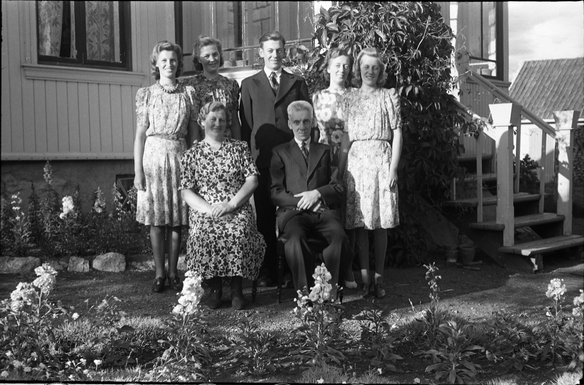 Nils og Mathilde Lundsten (sittende foran) på Kraby med barna (bak fra venstre) Kari, Magnhild, Arne, Hjørdis og Aase. Serie på fem bilder, og plasseringen nevnt foran gjelder bilde nr. 1. 
Nils var stasjonsmester på Kraby stasjon, og bildet er tatt ved boligen som var nærmeste nabo til stasjonen. 
Av de fem barna var det to tvillingpar, Arne og Hjørdis født 1920, og Kari og Aase født 1924.
