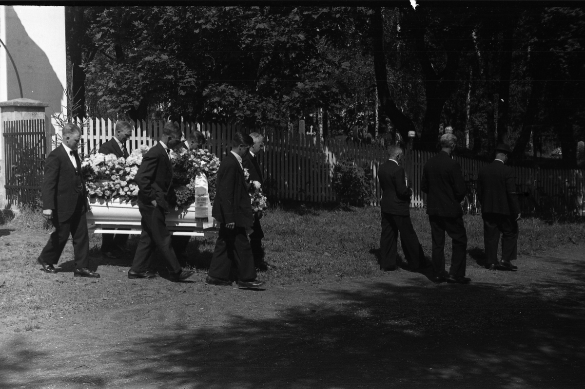 Fra en begravelse ved Hoff kirke. Serie på åtte bilder fra kisten bæres ut fra gravkapellet, og på kirkegården.