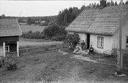 Tre personer foran våningshuset på bruket Nystuløkken på Kra