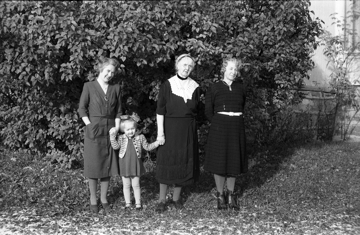 Tre kvinner og en jentunge foran Kvale-Hougens bolig Heggen på Kraby i Østre Toten. Nummer to fra høyre er Ella Eriksen som Kvale-Hougen hadde kjøpt Heggen av, og som fremdeles bodde der. Lengst til høyre trolig fru Kvale-Hougen. Den yngre kvinnen og jentungen er ikke identifisert.