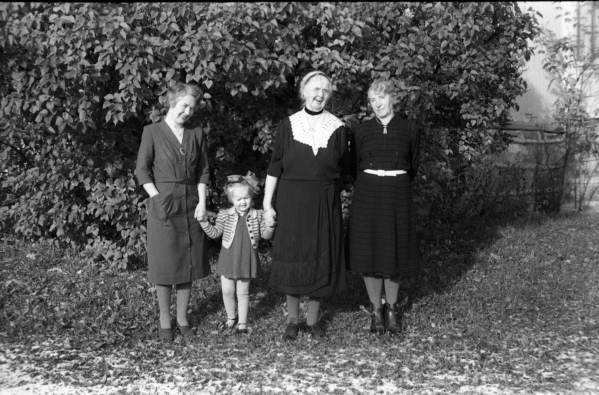 Tre kvinner og en jentunge foran Kvale-Hougens bolig Heggen på Kraby i Østre Toten. Nummer to fra høyre er Ella Eriksen som Kvale-Hougen hadde kjøpt Heggen av, og som fremdeles bodde der. Lengst til høyre trolig fru Kvale-Hougen. Den yngre kvinnen og jentungen er ikke identifisert.