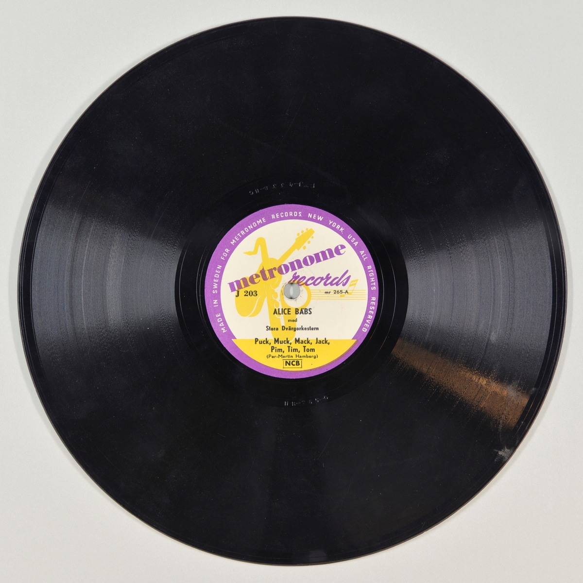 FTT.54207.01:
Svart grammofonplate laget av bakelitt og skjellak. Etiketten er lilla, gul og hvit, for tekst se "Påført tekst/merker". Det er bilde av en gitar, saksofon og en notestripe i gult mot hvit bunn og lilla innramming. 

FTT.54207.02:
Plateomslaget til platen er laget av brunt papp med trykk. På forsiden er det bilde av et dansende par (svarthvit tegning), for tekst se "Påført tekst/merker". På baksiden er det informasjon om utsalgssteder i Malmø.