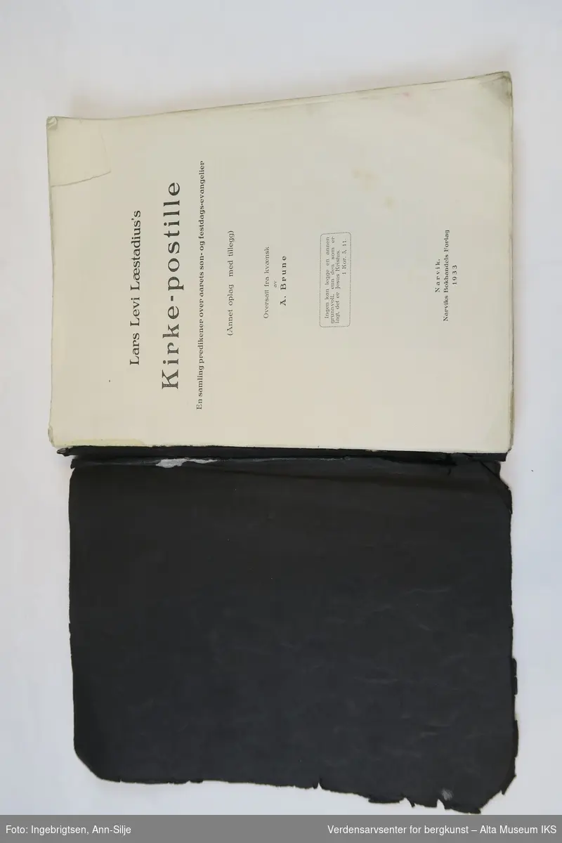 Heftet bok i A4-format med svarte permer.