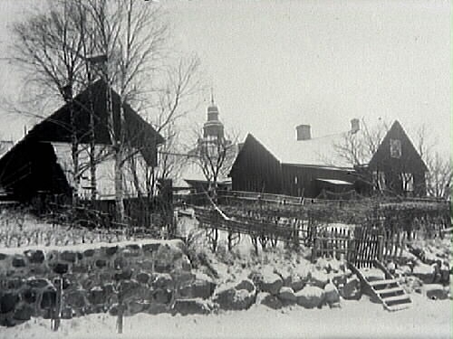 Träbebyggelse och Laholms kyrka i bakgrunden.