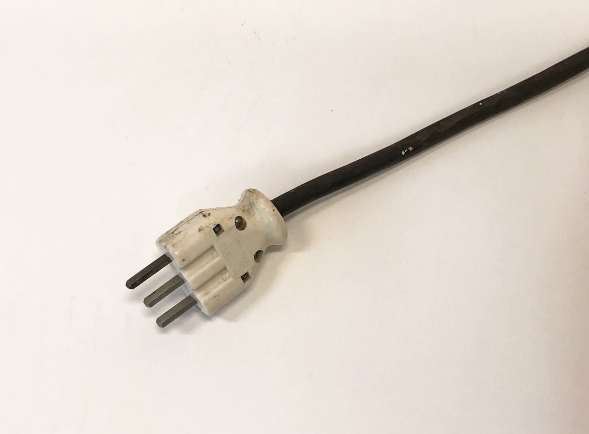 Elektrisk komfyr med bakvegg og tre kokeplater. Stekeovn med termometer på utsiden. I stekeovnen er det to tilhørende stekebrett. Lyspære på bakveggen.