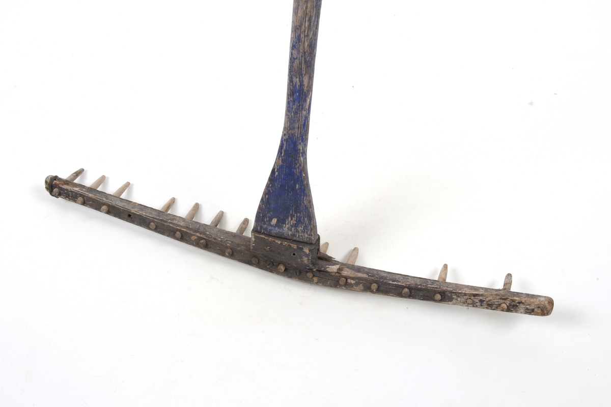 Trerive med rester av blåmaling. Brukt til å rake høy.