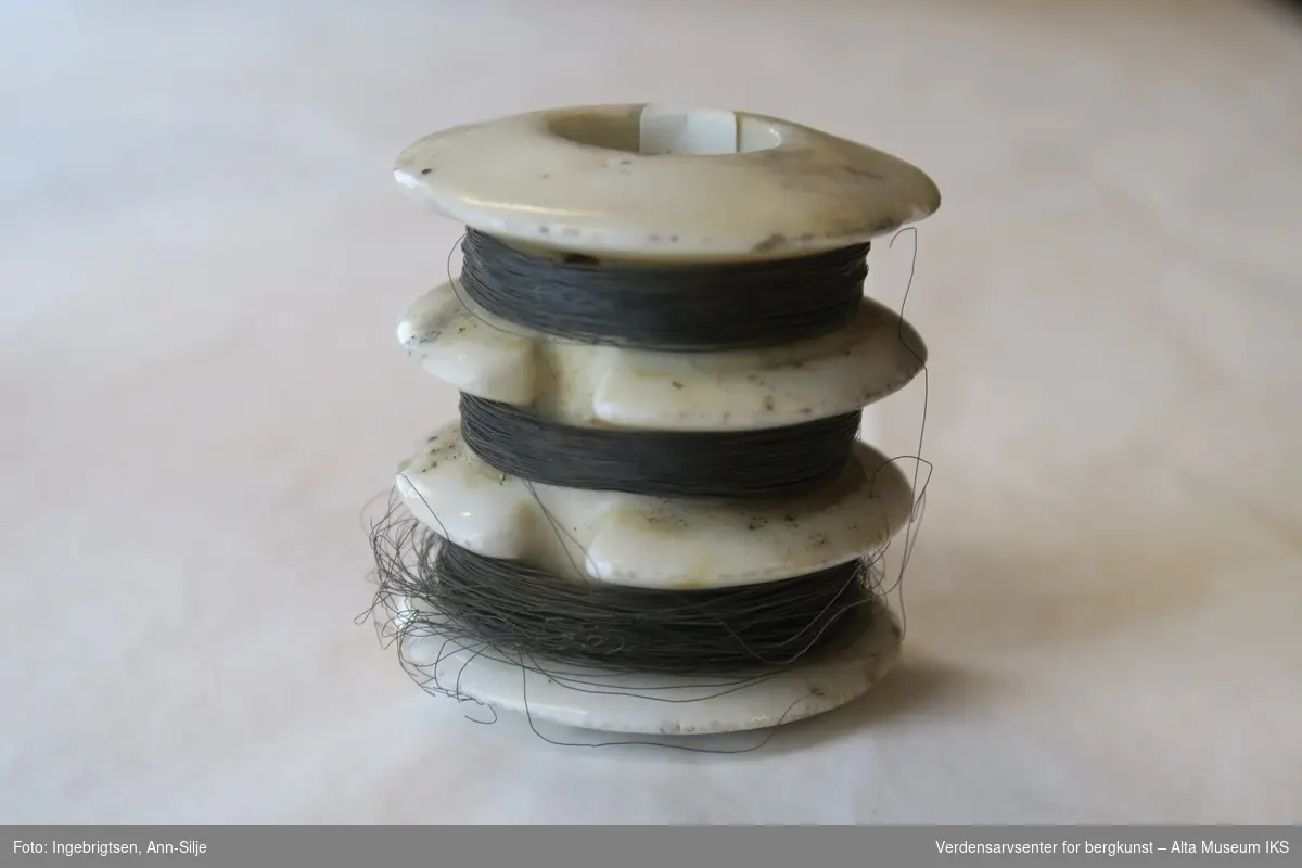Form: sylinder formet porselenstykke med tre sporer og hull i midten. I sporene er det surret kobbertråder.