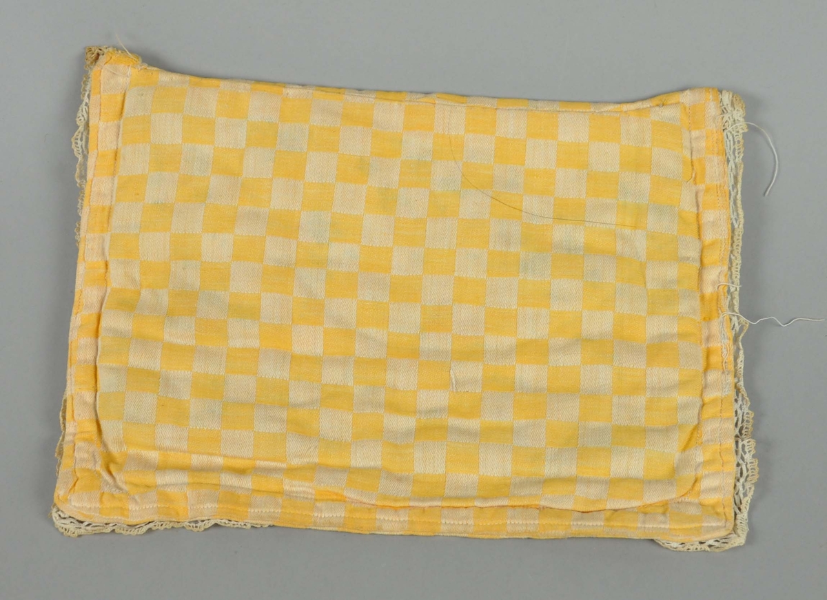 Pute til dukkevogn av tekstil i hvitt og gult, med rutenett-mønster. Det går hvite blonder langs tre av sidene.