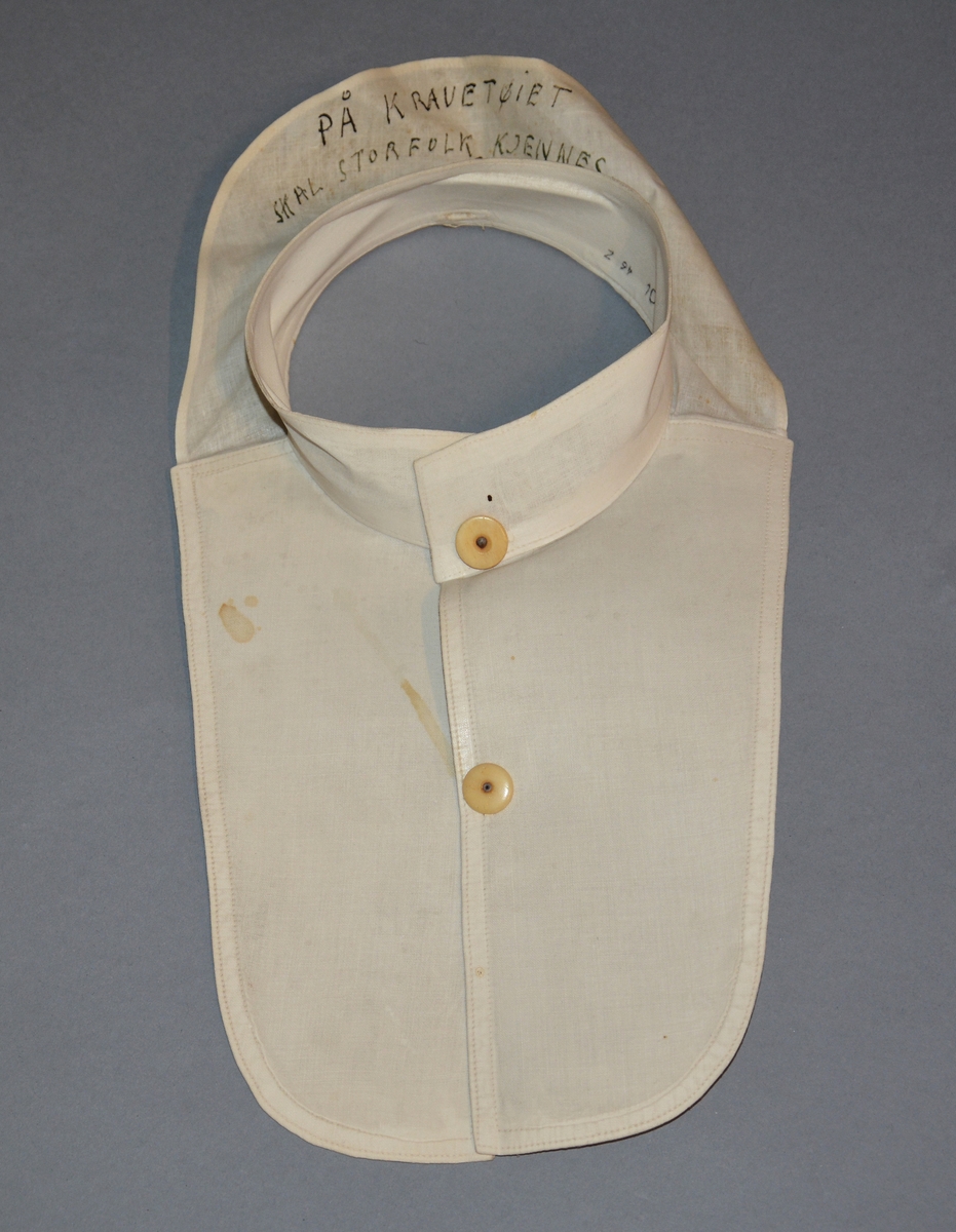 Løst, stivt skjortebryst med opprettstående krage, lukkes med 2 knapper midt foran. Til å ha under dressjakken som erstatning for skjorte. Maskinsøm.
