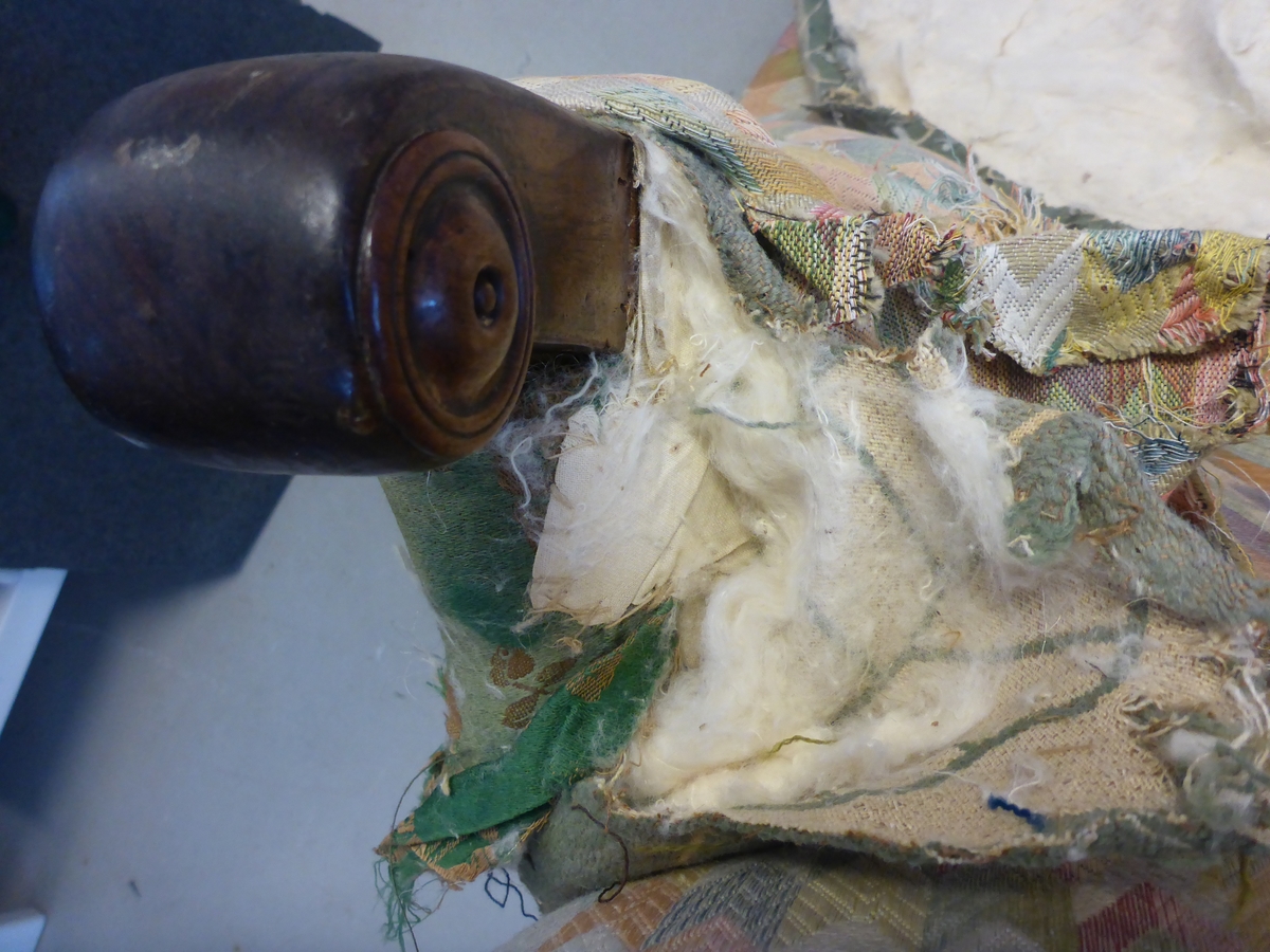 Stolen har en ramme av tre med dreide frambein som er beiset og oljet.