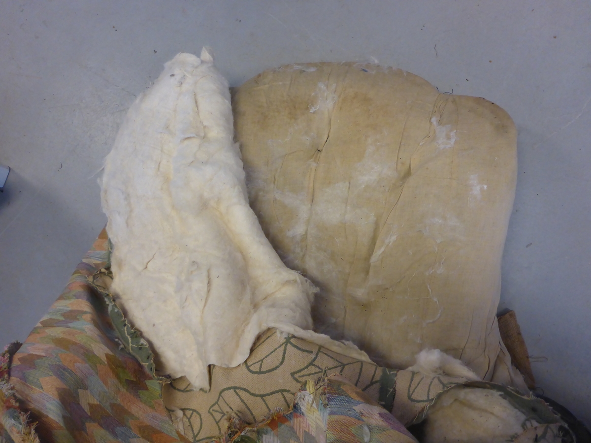 Stolen har en ramme av tre med dreide frambein som er beiset og oljet.