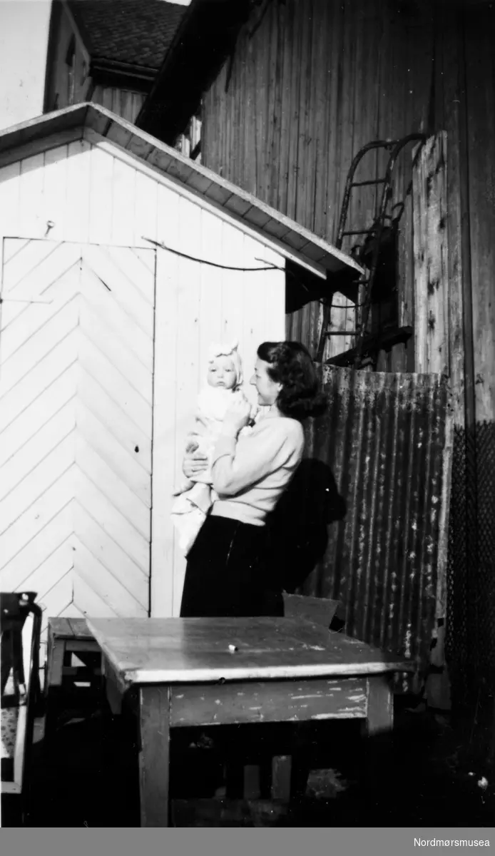 mor og barn, baby. brygge. Kristiansund 1950? Bildet inngår i en samling fra Rigmor Leren. Fra Nordmøre museums fotosamlinger.