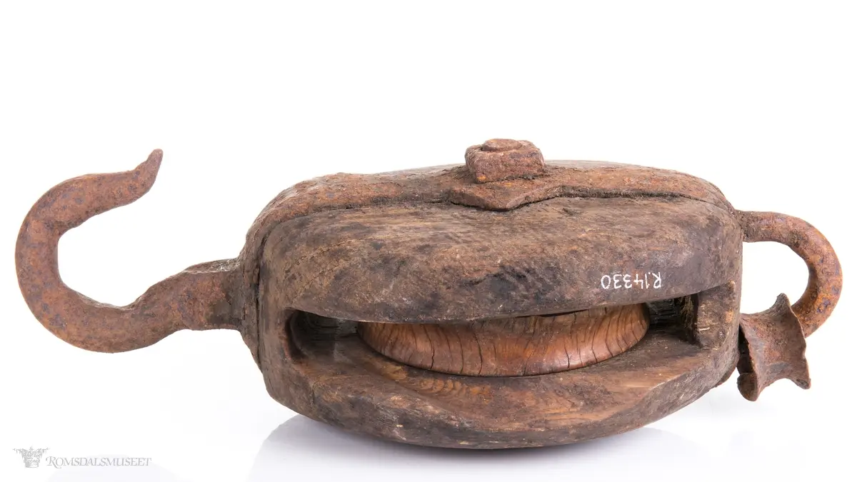 Treblokk med en enkelt skive eller trinse. Et kraftig jernbeslag griper om blokken og er festet med en gjennomgående bolt som er aksling for skiven. Beslaget avsluttets av en jernkrok på den ene siden og en jerning med en påfestet kause i den andre.