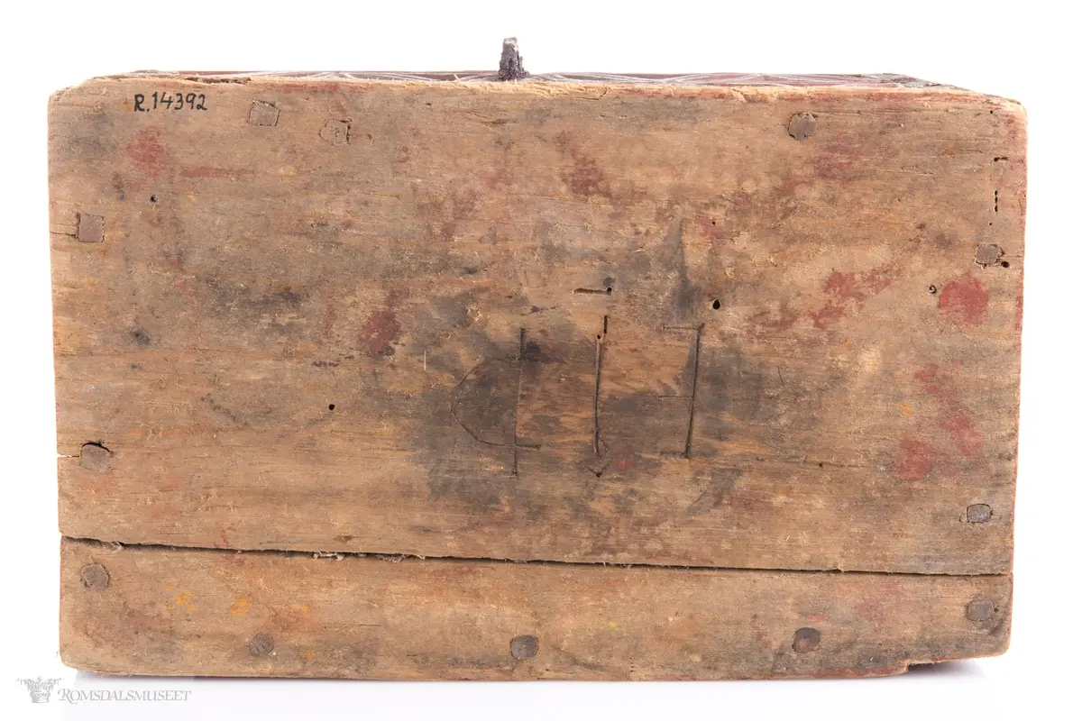 To sammenkomponerte seksbladsrosetter på hver langside. På kortsidene er det skåret ut fire klokkeformede strukturer fylt med spetter og border som til sammen ligner på et noe asymmetrisk solkors/kors.