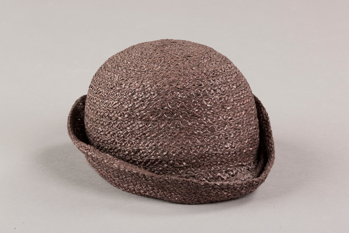 Form: Sirkelformet, avrundet  med brem og lita silkesløyfe med knapp. Bomullsbånd innvendig
Brem oppbrettet i spiralform med bredde økende til avslutning hvor den er festet til pullen med en plastknapp og sløyfe