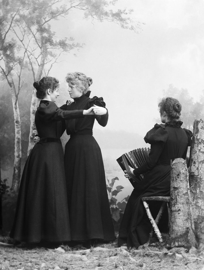 Kvinner, 2 som danser, 1 sitter og spiller trekspill, M.Baadstø, atelierbilde