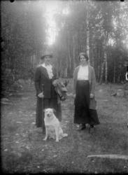 Kvinner, 2 stk med hunder i skogen