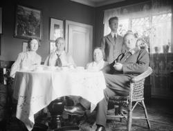 Gruppe på 5 mennesker rundt et bord i en stue. Fra venstre e