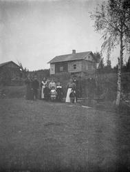 Gruppe små og store mennesker nedenfor hus under restaurerin