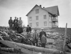 Gruppe ved plankestabel, til høyre byggmester Arne Raudbakke