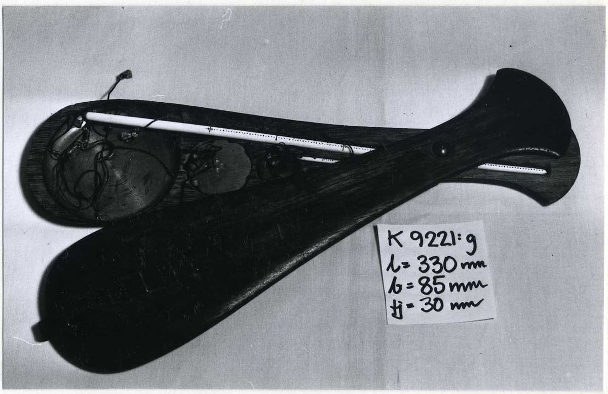 Balansvåg med skål av mässing, motvikt saknas, samt med rund pinne av ben (avbruten), med gradering i svart.