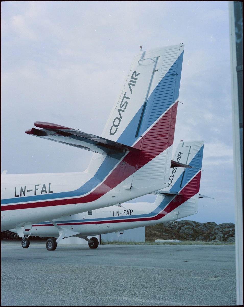 Bakenden på to fly fra "Coast Air" på en flyplass. Det står "LN-FAL" på det ene og "LN-FAP" på det andre.
