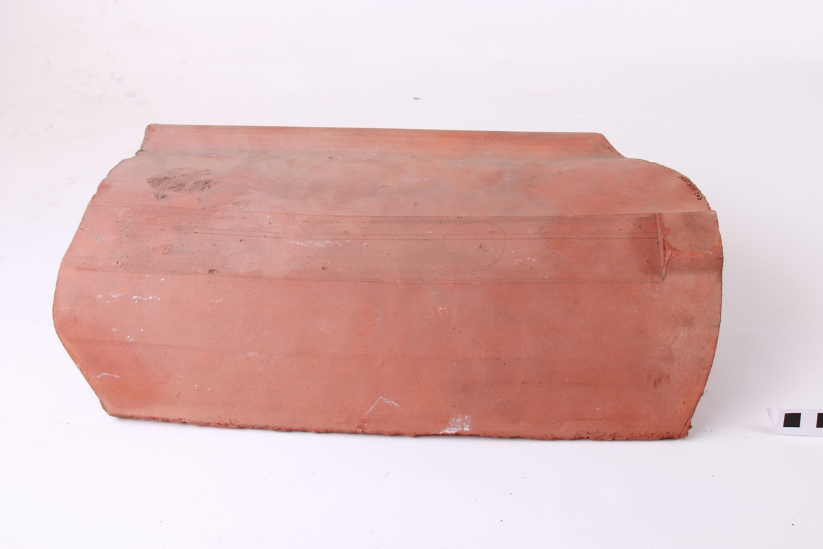 Krum takstein, maskinstrålte. Avskjering for panneknappen på baksida. Dette er den mest vanlege type takstein.