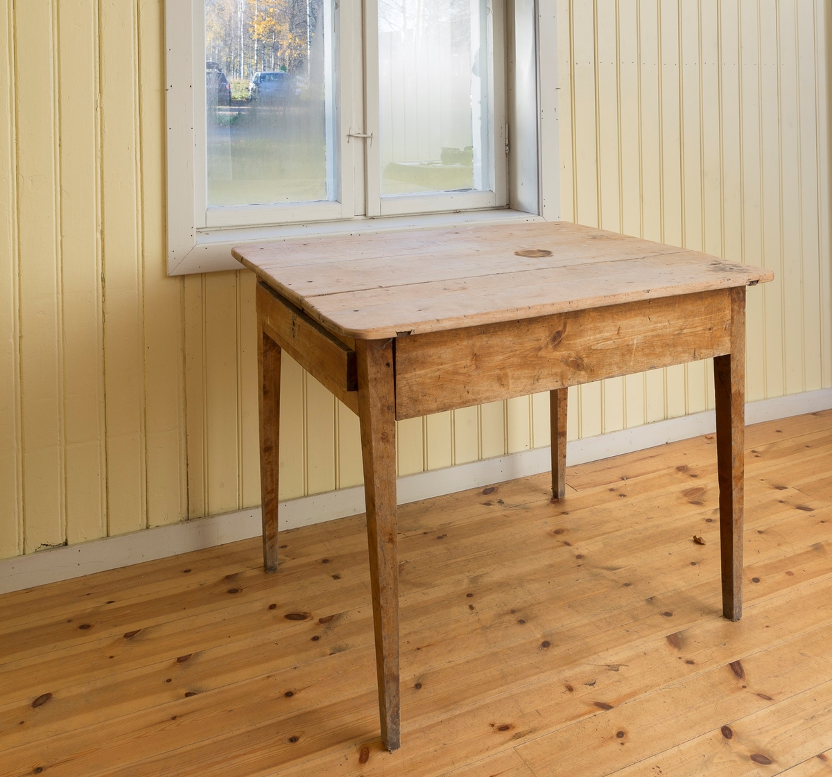 Spisebord med skuff. Satt sammen av 4 bordplater. Manglet lås og nøkkel. Lakkerte ben.