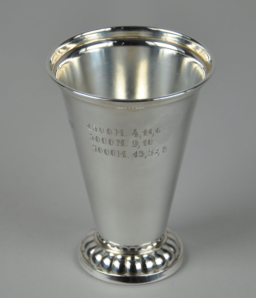 Pokal med dekor på stett og medaljong med bilde av et troll på sykkel