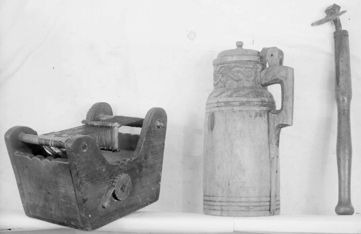 Trekasse med brystbom, garnbom og slagbom. Veven har renning og det er vevet et lite stykke bånd med mønster i rødt, blått og grønt.