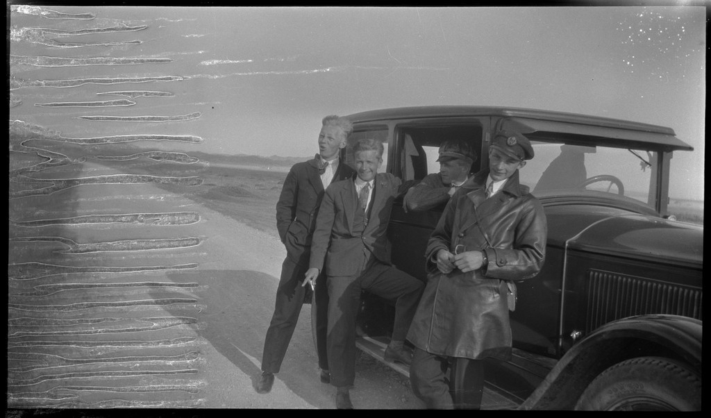 En gjeng unge menn foran en bil og ved kysten på Brusand.