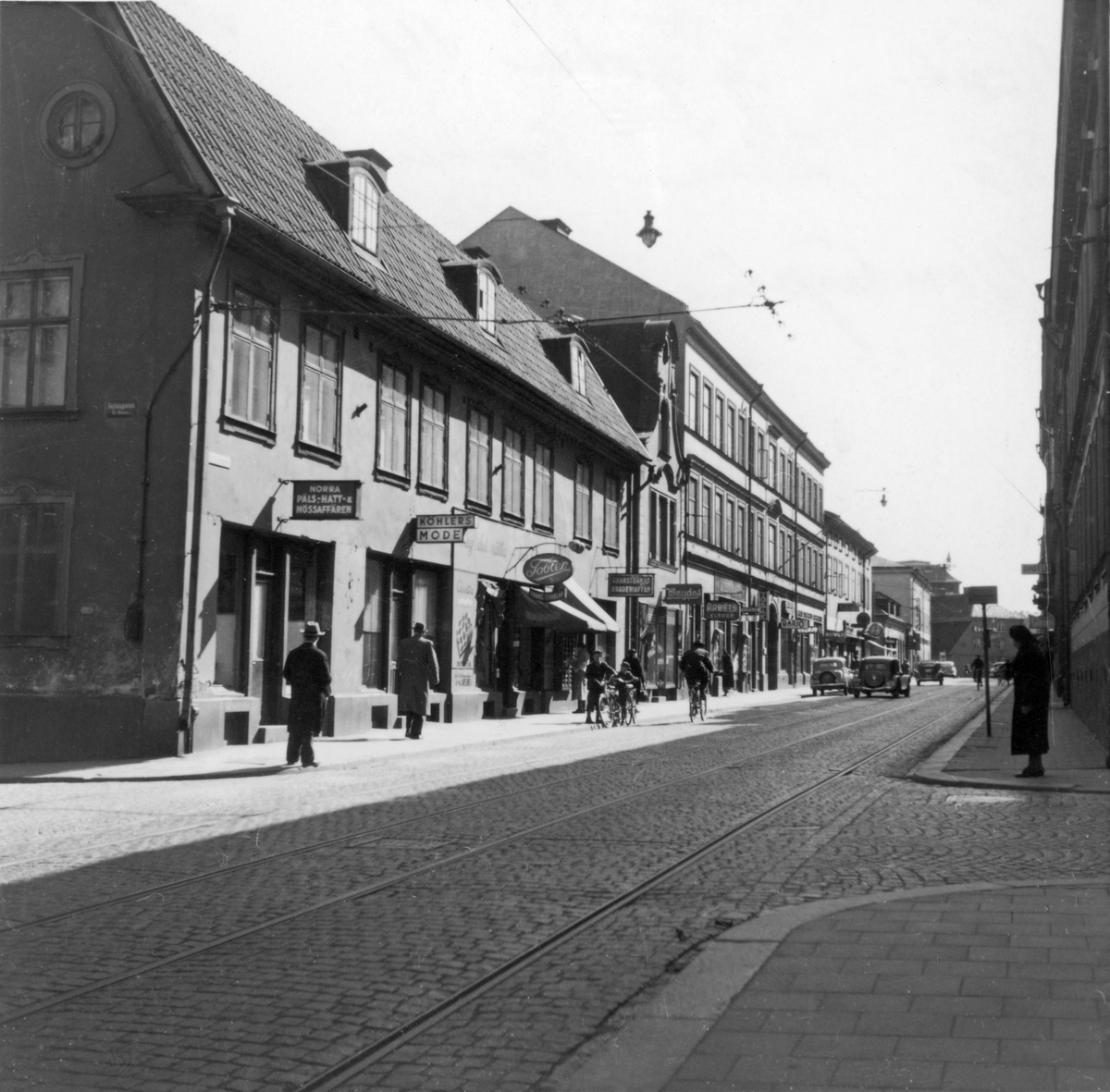 Parti av Kungsgatan i Norrköping. Närmast på vänster sida syns Arnbergska gården med anor från 1700-talet. Sedan följer del av affärsstråket längs Ettans spårvangslinje ner mot Skvallertorget. I fonden skymtar Bergslagsgården. Därbakom sticker taket på Strykjärnet upp som idag rymmer Arbetets museum.

På femtiotalet var Kungsgatans norra del en uttalad affärsgata. Gatan var då uppdelad i norra och västra Kungsgatan med Bergsbron som avdelare. Bland gatans många affärer visar bilden Beckmans Foto, Toblers Frukt och Choklad, Köhlers Mode, Norra Päls - Hatt- & Mössaffären, Granstrands broderiaffär, Weydes, med mera.