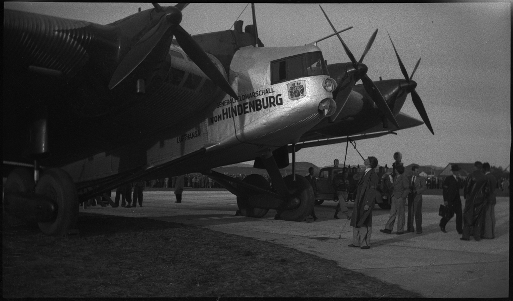 Bilder fra åpningen av den sivile flyplassen på Sømmesletta på Sola. Bildene viser folk som titter på flyene og helikoptrene som besøkte flyplassen fra inn- og utland i anledning åpningen. Det er flere bilder fra et stort passasjerfly fra Lufthansa med påskriften "Generalfeldmarschall von Hindenburg" og "D-APIS". Det er også et bilde fra en kanonbåt.