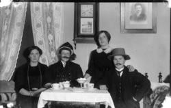 To kvinner og to menn ved kaffibordet