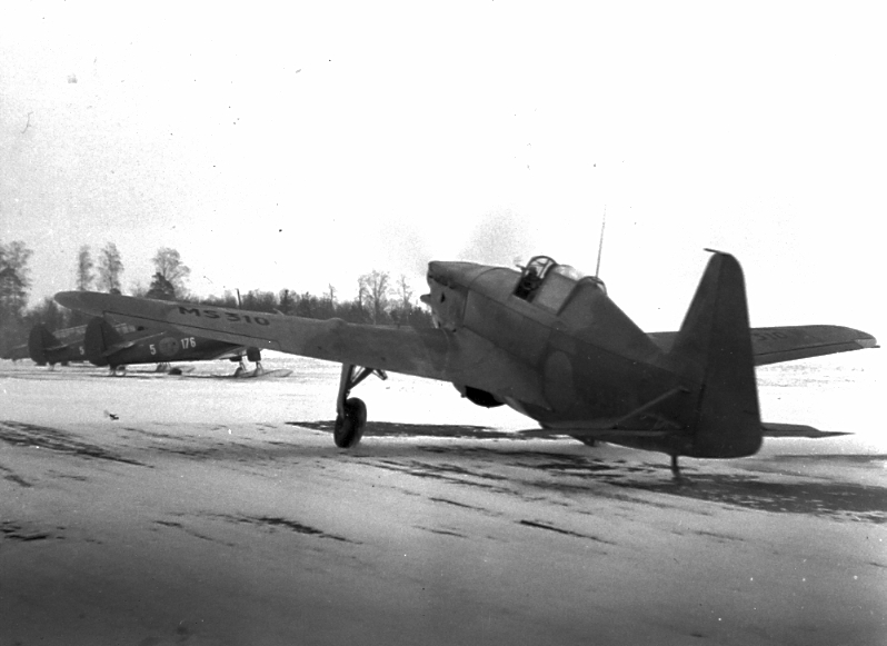 F6 Karlsborg 1940. 30 st franska Morane-Sauliner M.S 406 som gåva till Finland, anländer till Malmö packade i lådor och uppmonterades på Bulltofta av 5 franska mekaniker. Finska piloter flög planen via Västerås till Finland. Man hade tillstånd att mellanlanda på F6, men bara 2 flygplan använde sig av tillståndet. Flygplanstypen hade en kanon, troligen 20 mm, som sköt genom Propell-navet, samt en finkalibrig kulspruta i vardera vingen, kaliber troligen mindre än 8 mm. Bilden visar MS310. I bakgrunden några SK14 inlånade till flottiljen från Ljungbyhed. Albumet är en del av en donation från Karl-Axel Hansson, Karlsborg. Förteckning över hela donationen finns i albumet samt som Word-dokument.