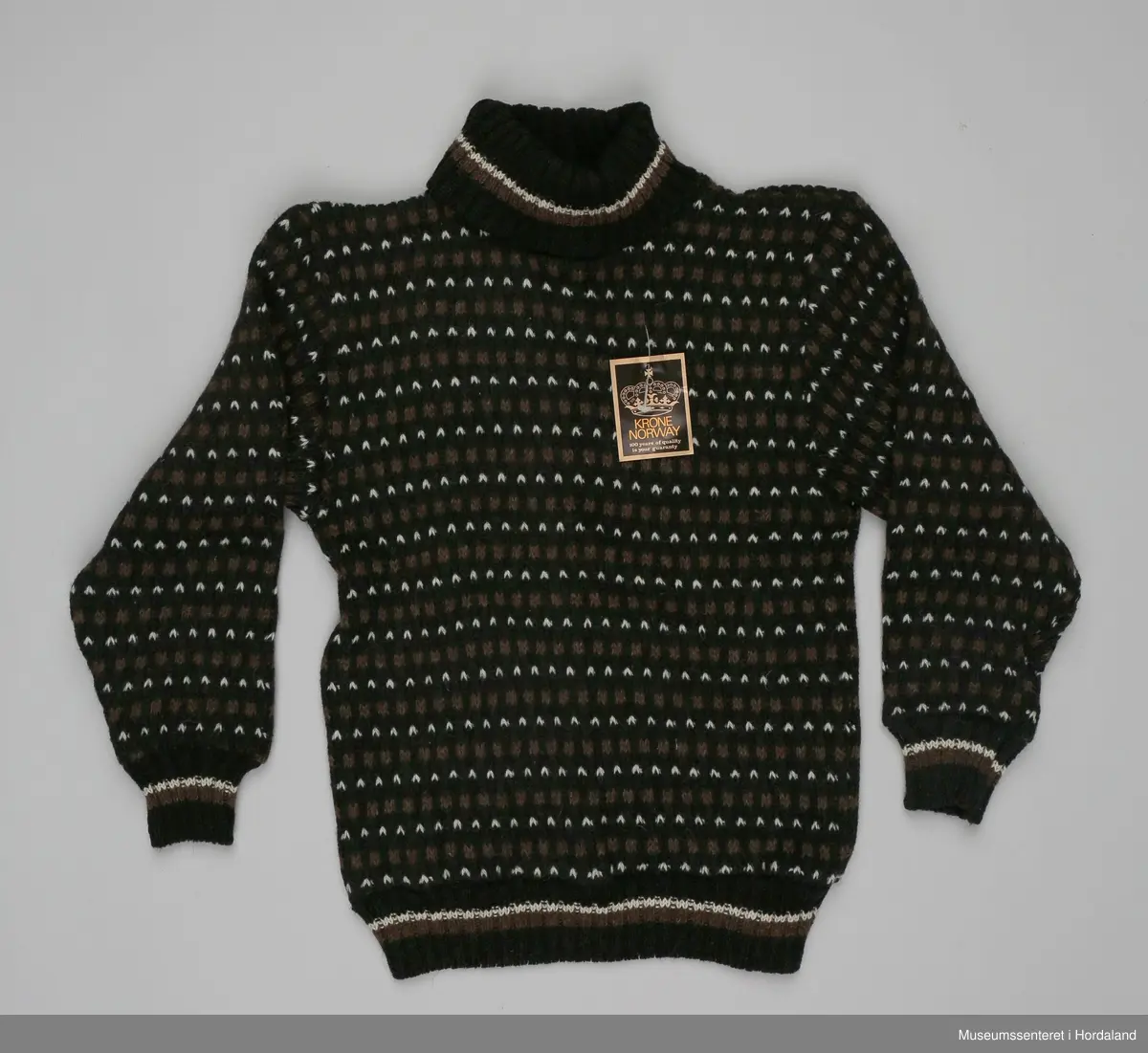 Høghalsa ullgenser/islender i svart, brunt og kvitt, med stripete vrangborder.